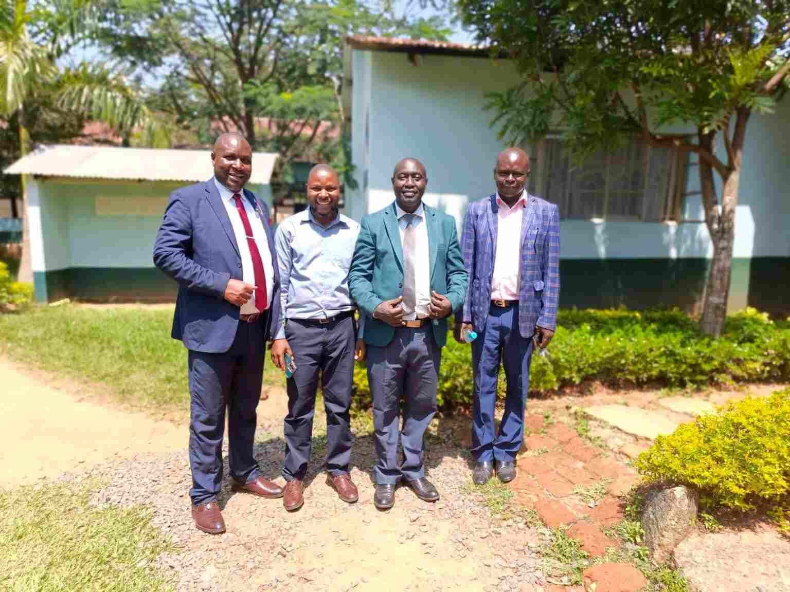 School management team photo in front of the administration block at Mwibale Senior School